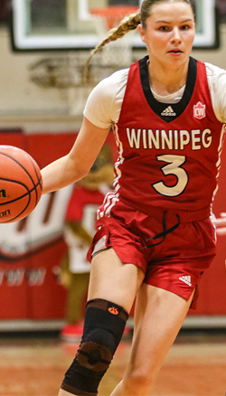 a player dribbling a basketball while the opposing team tries to stop her